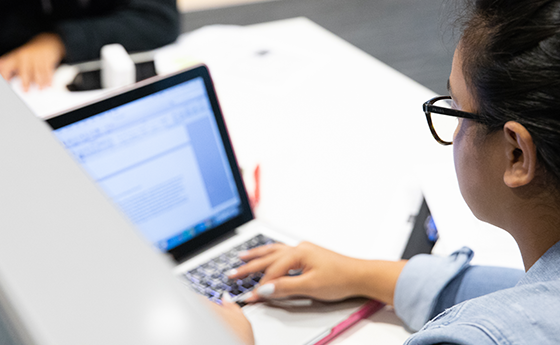 Student typing on a laptop