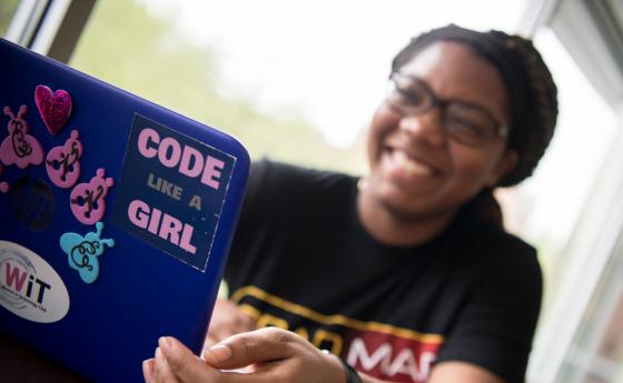 Girl on laptop with "Code like a Girl" sticker on it