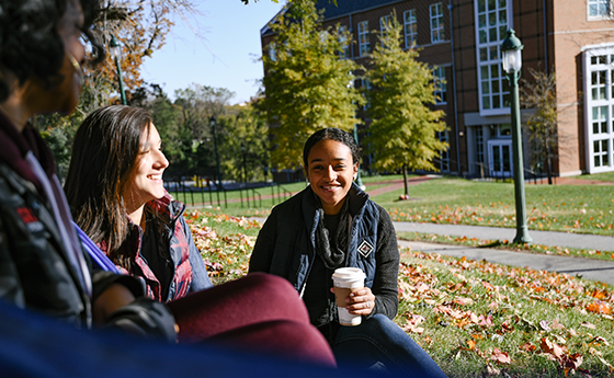 students drinking coffee outside on campus