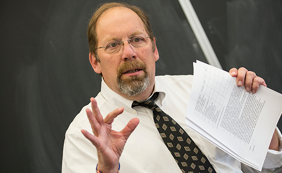 Professor holding a piece of paper and lecturing