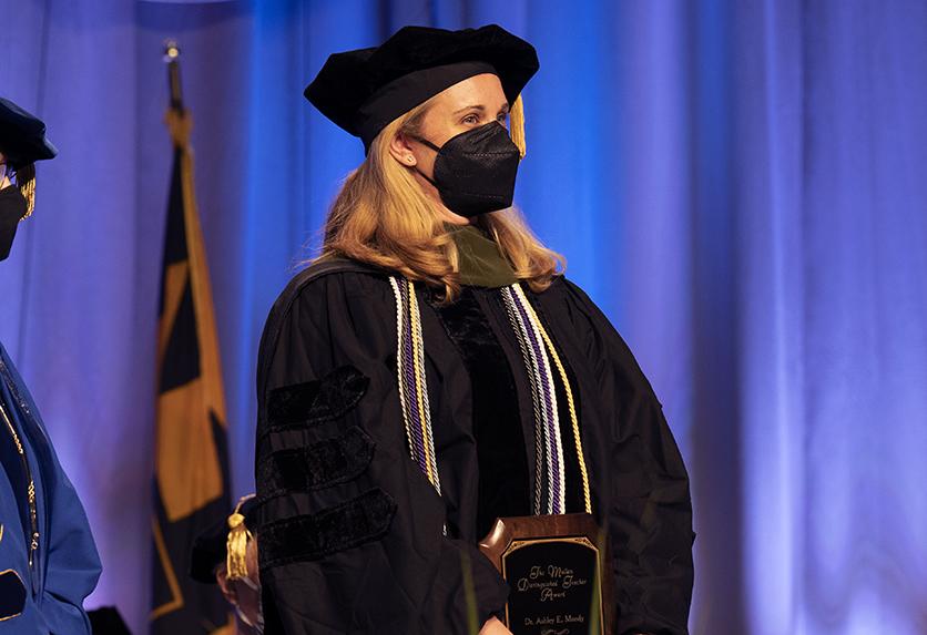 Dr. Moody holds the Mullan Award plaque at NDMU's commencement ceremony