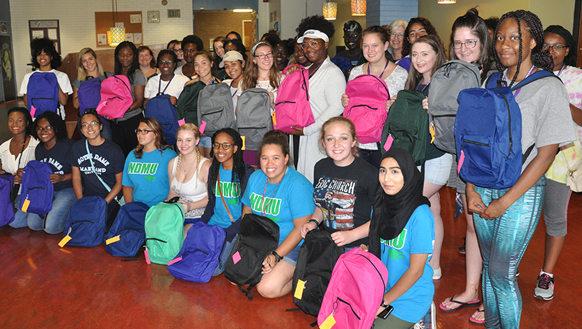 Group photo of students holding backpacks