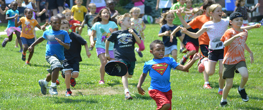 Many kids running across the grass