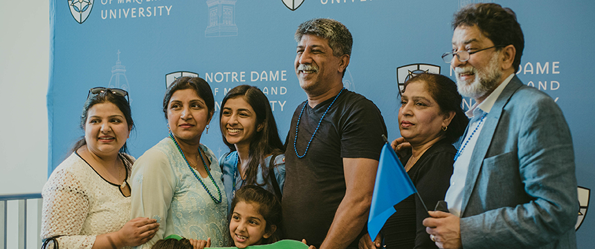 Family poses in front of NDMU backdrop