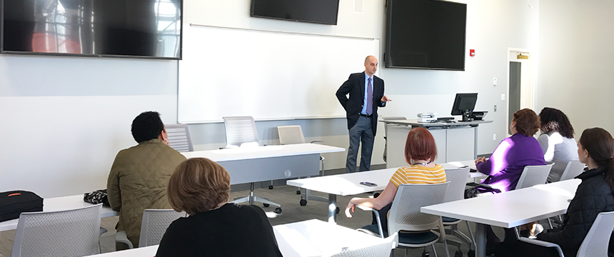 man at the front of the global digital classroom speaking 