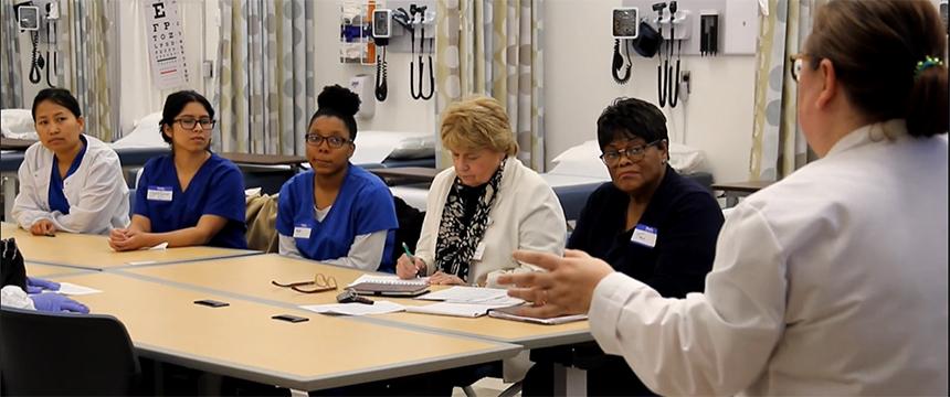 Several nurses are briefed at a table