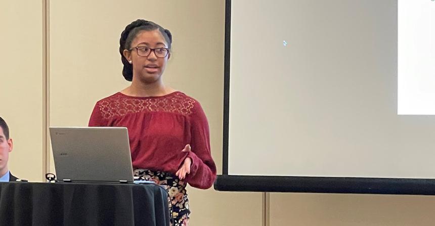 Arianna Clark presents to her audience from a podium