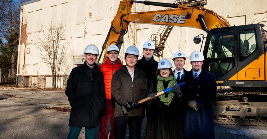 Group shot of NDMU and Brightview officials in front of construction equipment