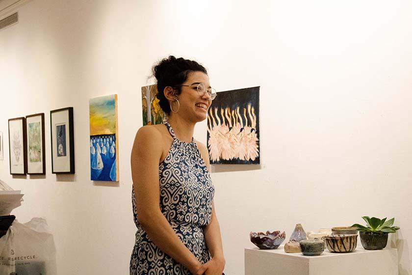 Art student standing in front of her pottery work