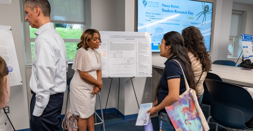 Male student presents his research to an audience while standing at a podium