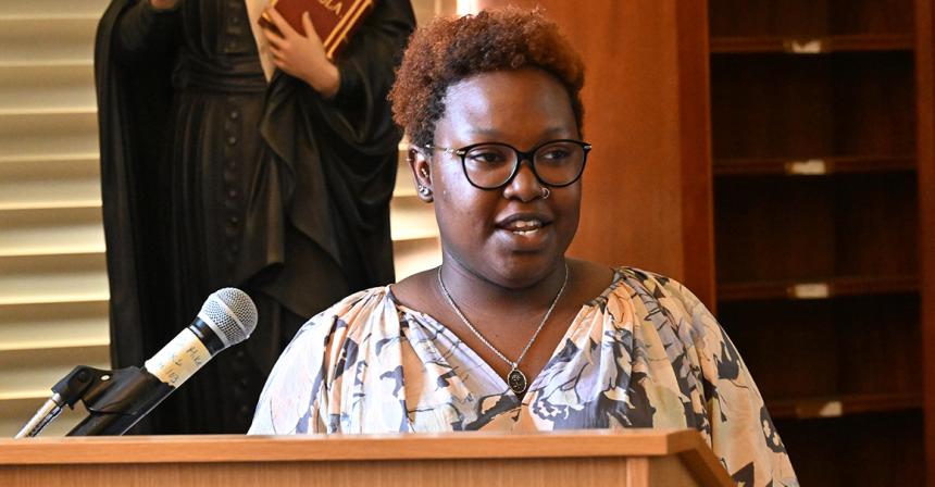 Student stands at a podium for a presentation