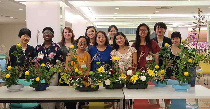 group of girls in front of flower