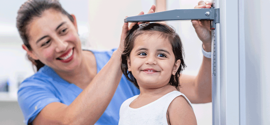 Nurse measuring the height of a young girl