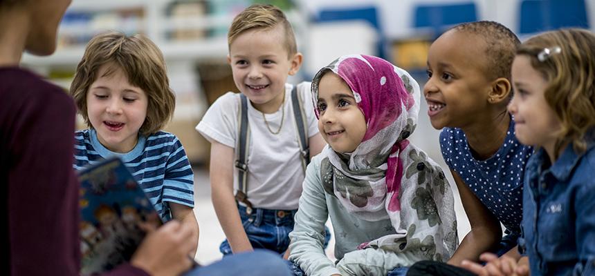 teacher sitting with students in a group