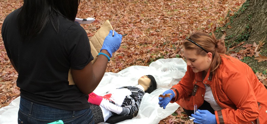 two students working outside testing samples of ground