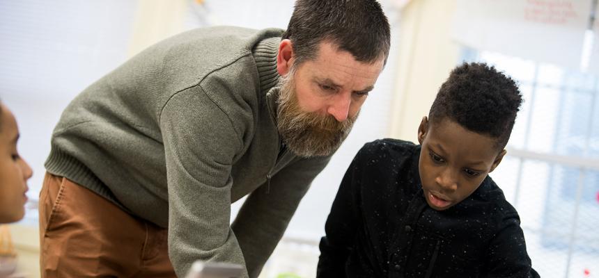 teacher helping student in class