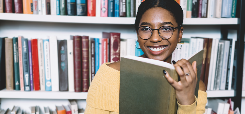 Woman reading in front of a bookshelf