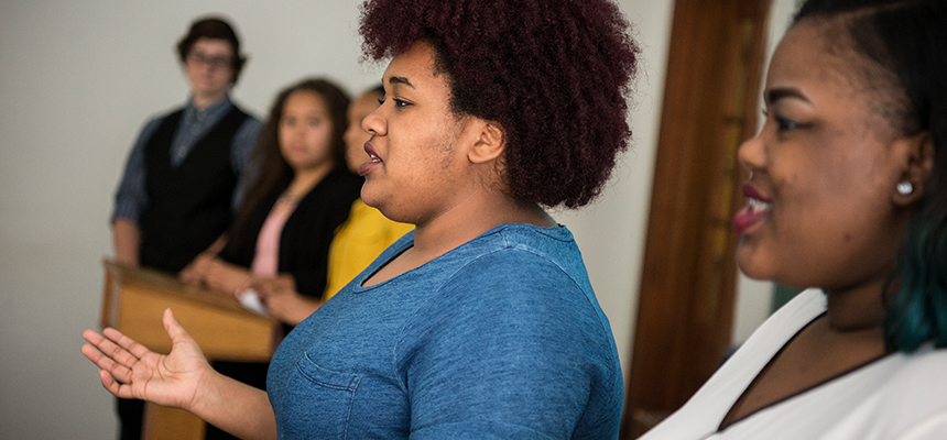 female students standing in front of class giving presentation