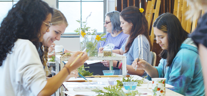 Group of art therapy students at a table working on art projects