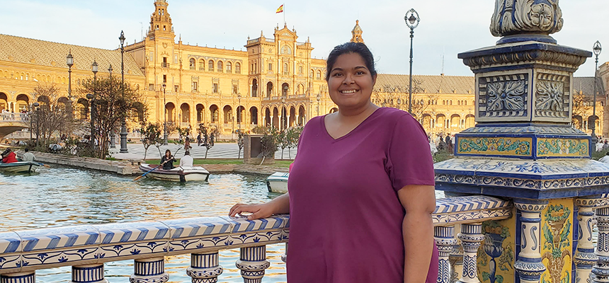 Student standing on a bridge in a Spanish city 