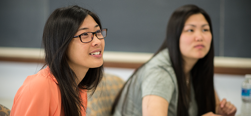 Two female students near a blackboard