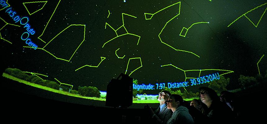 student looking at stars in planetarium