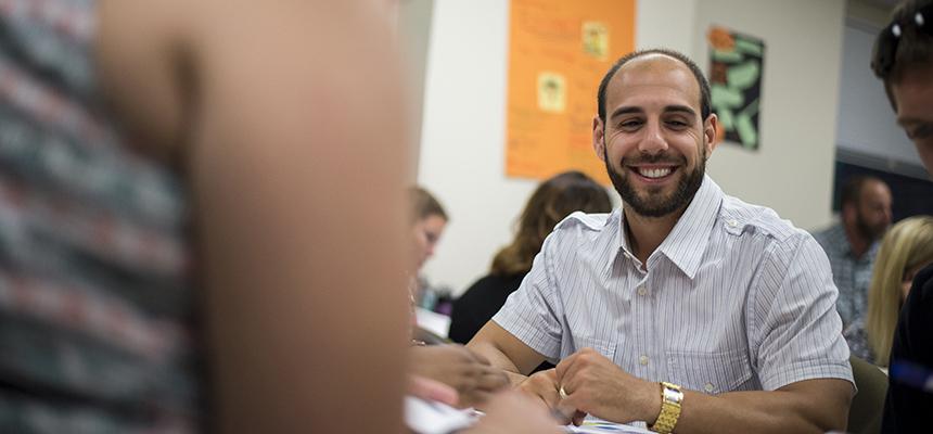 male student working with a group of other students