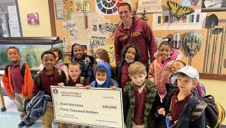 Scott Hartman and his students pose with a ceremonial check from the CIA